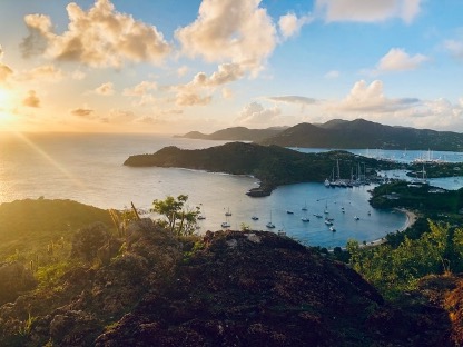 A picture of one of Antigua's shores as the sun sets on the left side.