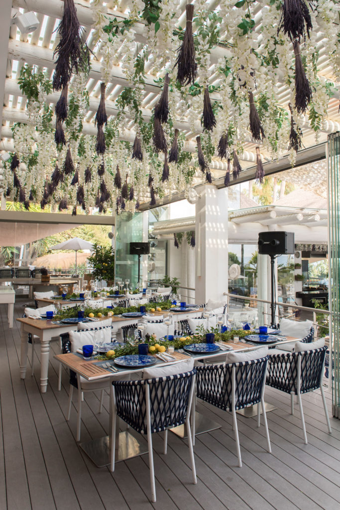 Event setup with flowers hanging from the ceiling at seaside restaurant