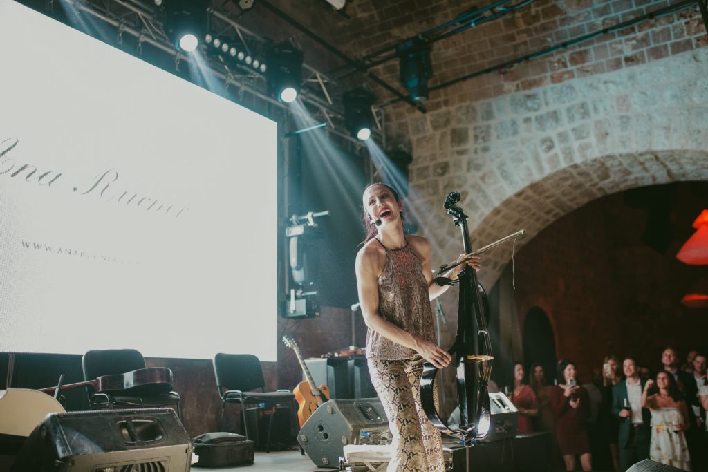 Electric cellist on stage with bright lighting