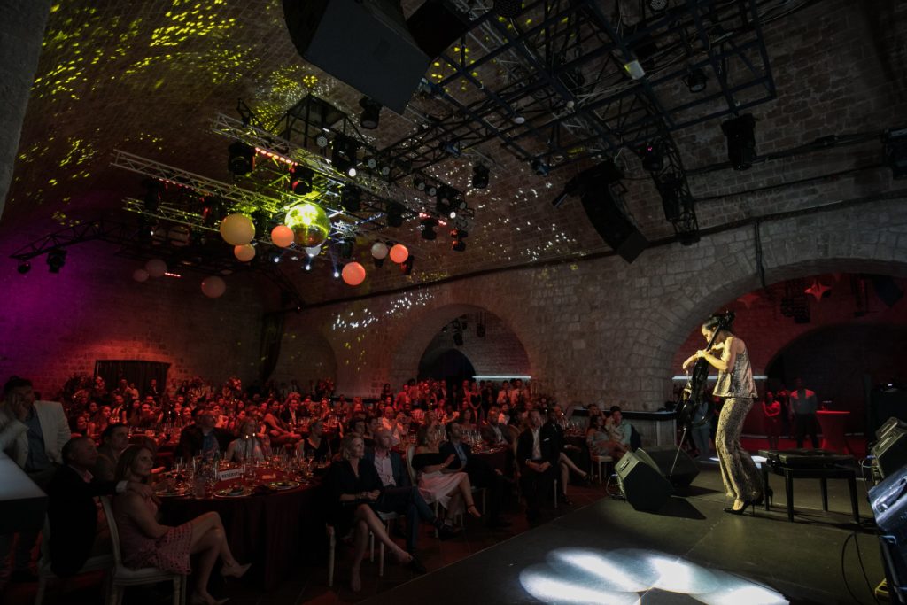 Electric cellist plays for a group of corporate guests eating dinner