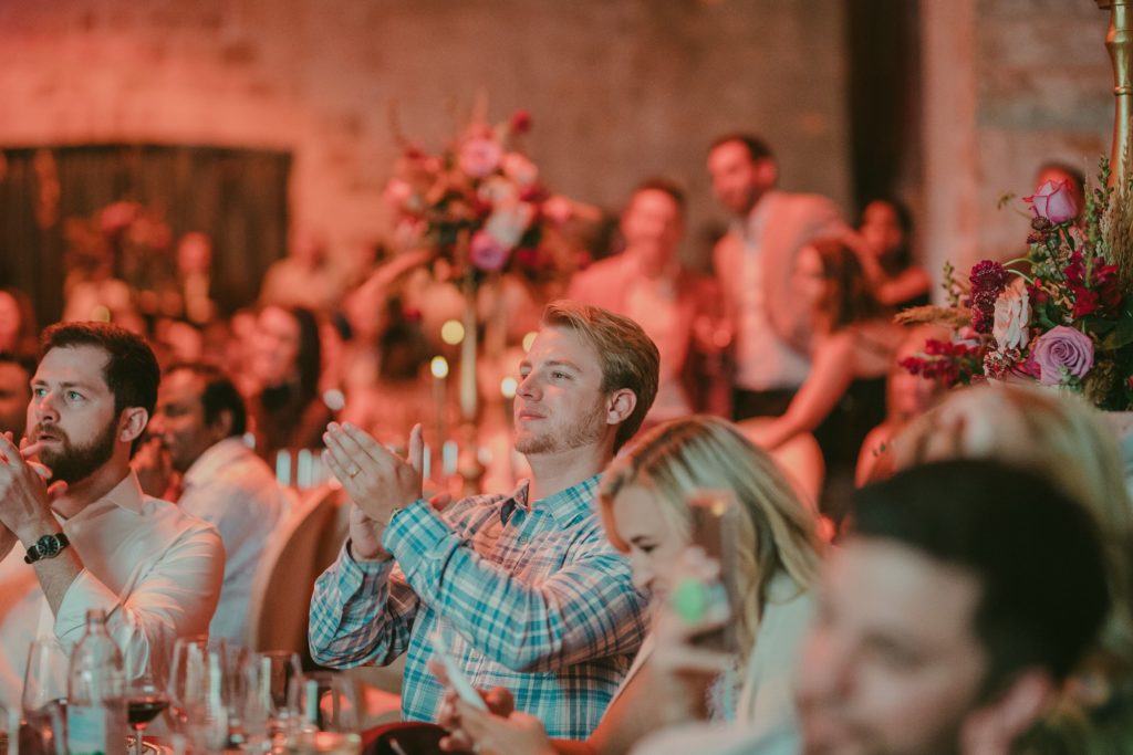 Attendees at dinner clap for musical performers