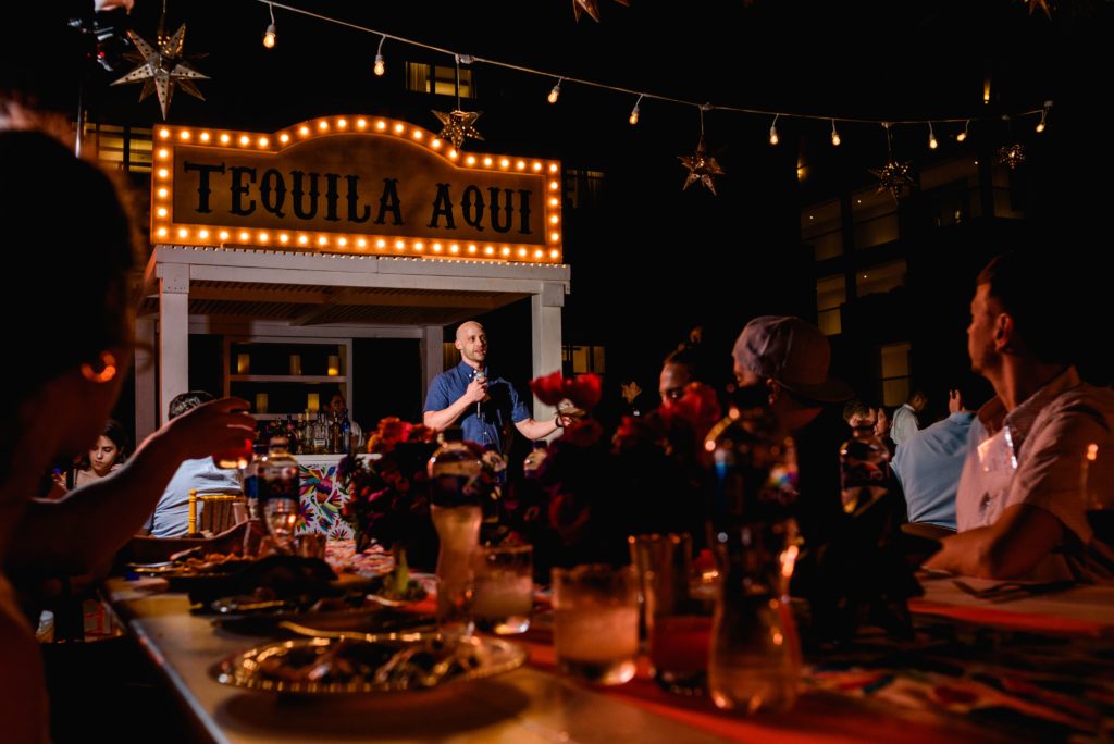 Speaker addresses a group at an outdoor evening event in Riviera Maya, Mexico