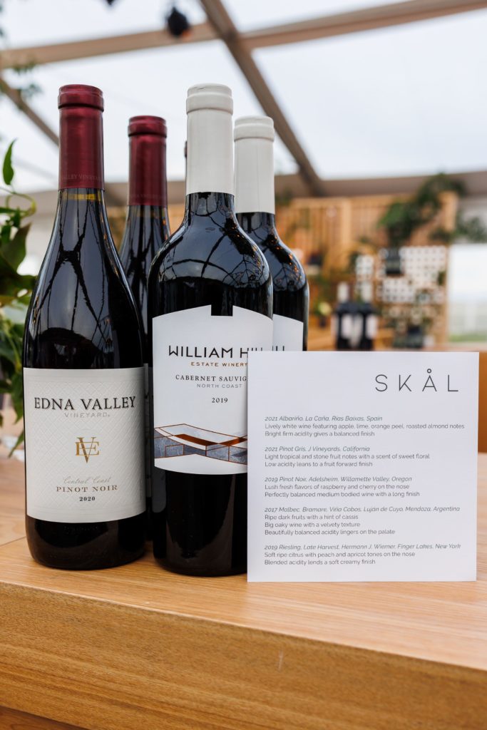 Bar set up with bottles of wine next to a custom card with tasting notes