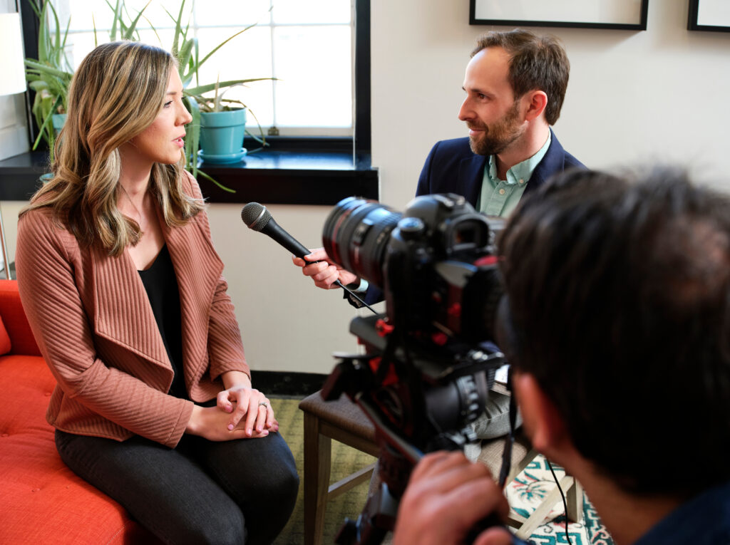 David interviews Deanna in front of a camera