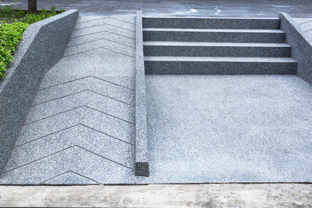 wheelchair ramp and stairs leading into a corporate building