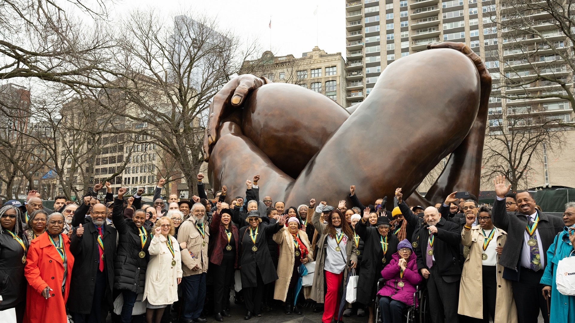 Honorees gather at the Embrace monument for its unveiling January 2023