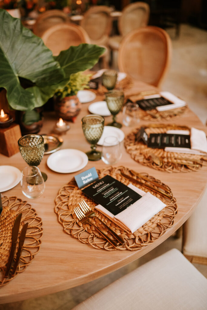 Table setting with rustic placemats and tropical leaves